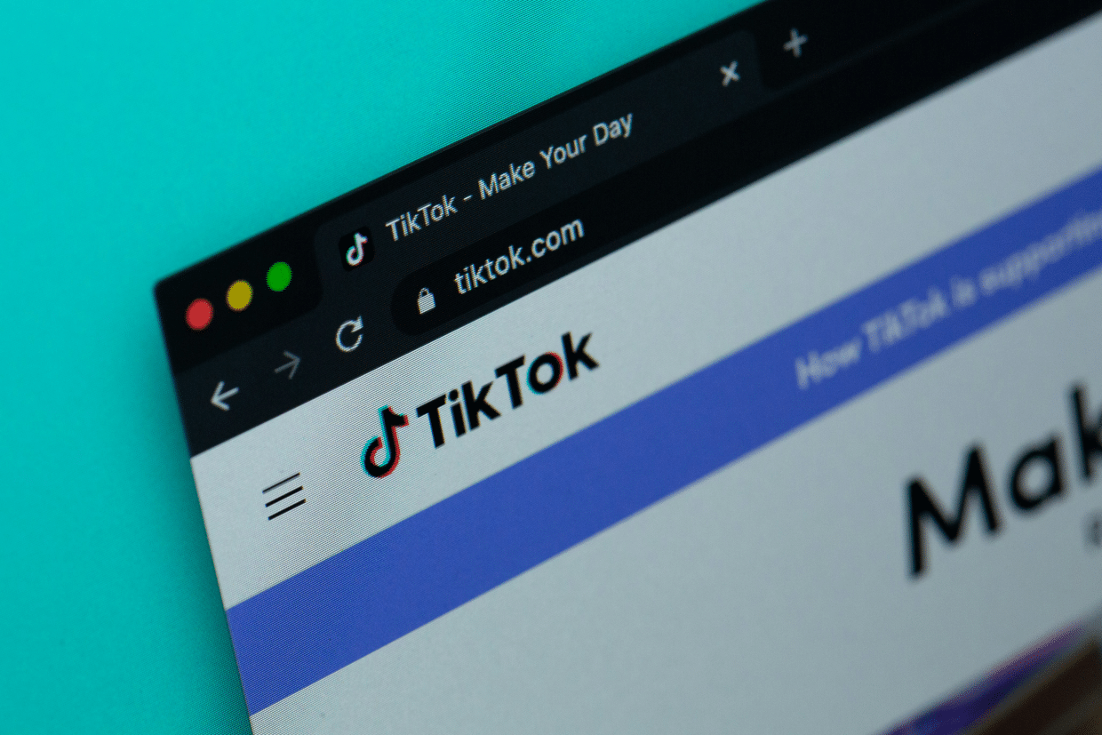 A close-up image displays the TikTok website homepage on a computer scree